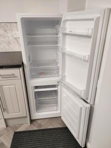 an empty refrigerator with its door open in a kitchen at Local to Russells Hall Hospital in Brierley Hill