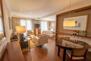 a living room with a hotel suite with a bedroom at George V Alto De Pinheiros in Sao Paulo