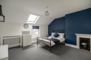 una camera da letto con una parete con accento blu e un letto di Grange House by Horizon Stays a Hartlepool