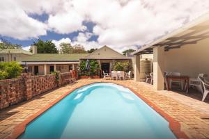 a swimming pool in the backyard of a house at Oak lodge Guest House in Grahamstown