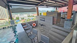 a rooftop bar with chairs and a swimming pool at The Gig Hotel in Patong Beach