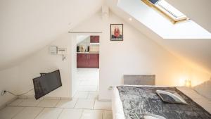 Dormitorio tipo loft con cama y TV en Smart Confort 5 - Appartement confort et stylé, en Troyes