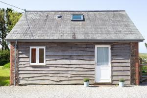 a log cabin with a white door and two windows at The Orchard in Hartland