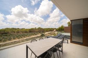 eine Terrasse mit Tisch und Stühlen und einem großen Fenster in der Unterkunft Bonifacio in Villacosta
