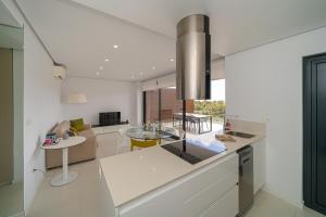 eine Küche und ein Wohnzimmer mit weißen Wänden und einer Kücheninsel in der Unterkunft Bonifacio in Villacosta