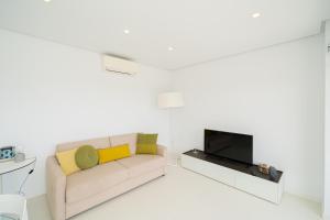 ein Wohnzimmer mit Sofa und Fernseher in der Unterkunft Bonifacio in Villacosta