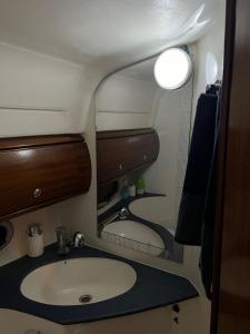 ein Bad mit einem Waschbecken und einem Spiegel in der Unterkunft Maser II ( Excelente Mini Yate ) in Valencia