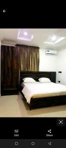 a bedroom with a large bed with white sheets at Skenyo Hotel & Apartments in Ketti
