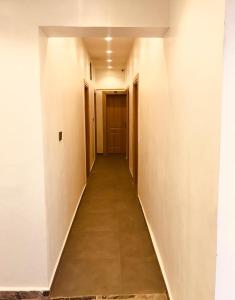 a hallway with a long corridor with white walls at Skenyo Hotel & Apartments in Ketti