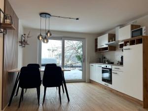 a kitchen with a table and chairs and a kitchen with a window at Alpinsuite - modern - elegant in Waltenhofen
