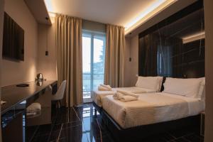 a hotel room with a bed and a large window at Emma Hotel Bologna Fiera in Bologna