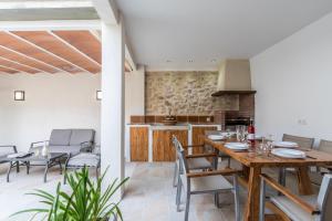 a kitchen and dining room with a wooden table and chairs at Historic Pollensa Townhouse - Casa Bugera - 3 Bedrooms - Private Pool - Walking Distance to Centre in Pollença