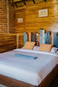 a large white bed in a wooden room at Sekumpul Bali Hidden Space in Singaraja