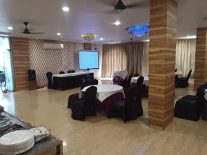 a conference room with a table and chairs and a screen at The Park, Itarsi in Itārsi