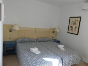 1 dormitorio con 1 cama con 2 toallas en PRECIOSO ÁTICO VISTAS MAR Y MARISMAS, en Isla Canela