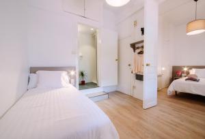 een witte slaapkamer met een bed en een spiegel bij Hostalet de Barcelona in Barcelona