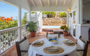 a dining table on a porch with a view of the ocean at Saint Barth Villa 15 in Pointe Milou