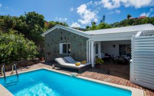 a swimming pool in front of a house at Saint Barth Villa 15 in Pointe Milou