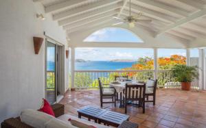 a living room with a table and chairs on a patio at Saint Barth Villa 15 in Pointe Milou