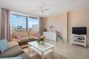 ein Wohnzimmer mit einem Sofa und einem TV in der Unterkunft Apartment Manzanera 1 - PlusHolidays in Calpe