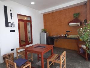 cocina con mesa, sillas y nevera en The Mango House Ahangama, en Ahangama