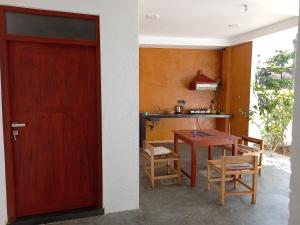 una puerta que conduce a una cocina con mesa y sillas en The Mango House Ahangama, en Ahangama