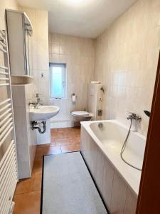 a bathroom with a tub and a toilet and a sink at Göltzschtal Apartment in Mylau
