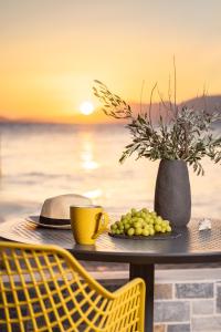une table avec une tasse de café jaune et une assiette de fruits dans l'établissement 8MOONS Elegant Apartments, à Kokkari