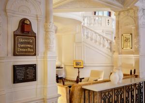un vestíbulo con una escalera y un jarrón sobre una mesa en St. Ermin's Hotel, Autograph Collection, en Londres