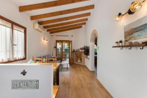 eine Küche und ein Wohnzimmer mit weißen Wänden und Holzdecken in der Unterkunft Apartamento en moraira con piscina in Moraira + 25 Fotos