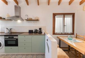 eine Küche mit weißen Schränken und einem Holztisch in der Unterkunft Apartamento en moraira con piscina in Moraira