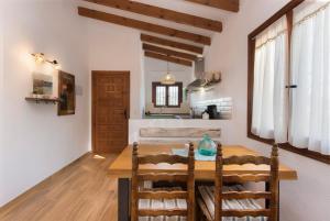 eine Küche und ein Esszimmer mit einem Holztisch in der Unterkunft Apartamento en moraira con piscina in Moraira