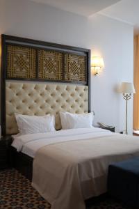 a bedroom with a large bed with a large headboard at KADORR Hotel Resort & Spa in Odesa