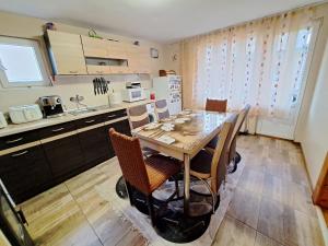 a kitchen with a table and chairs in a kitchen at Guest House Freya in Beli Iskar