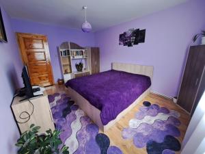 a bedroom with a purple bed and a purple rug at Guest House Freya in Beli Iskar