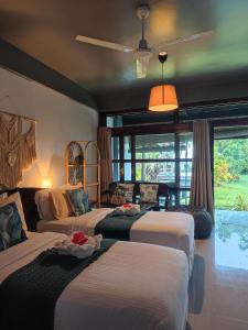a hotel room with three beds and a large window at Daluyong Beach Resort in General Luna