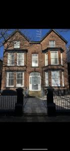 a large brick building with a white door at No 2 at Mannering, Large 1 bed near Lark Lane in Liverpool