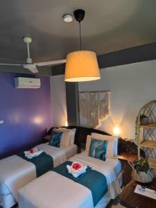 two beds in a room with purple walls at Daluyong Beach Resort in General Luna