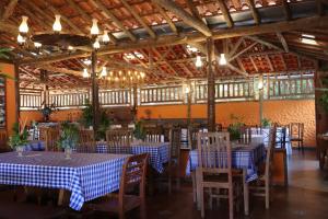 a dining room with blue and white tables and chairs at Ecopousada Serra Verde in Glaura