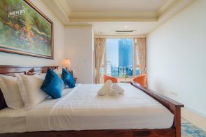 ein Schlafzimmer mit einem großen weißen Bett mit blauen Kissen in der Unterkunft Son&Henry Cantavil Korean Apt in Ho-Chi-Minh-Stadt