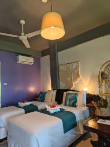 two beds in a room with purple walls at Daluyong Beach Resort in General Luna