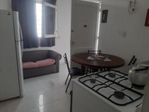 Hostel positivo في بوينس آيرس: مطبخ وغرفة معيشة مع موقد وطاولة