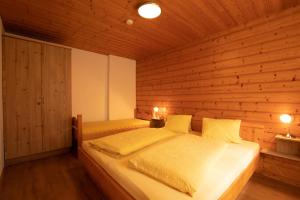 a bedroom with a bed in a wooden wall at Auers Ferienwohnung ITD100 in Itter