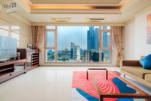 ein Wohnzimmer mit einem großen Fenster mit Stadtblick in der Unterkunft Son&Henry Cantavil Korean Apt in Ho-Chi-Minh-Stadt
