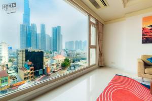 Schlafzimmer mit einem großen Fenster mit Stadtblick in der Unterkunft Son&Henry Cantavil Korean Apt in Ho-Chi-Minh-Stadt + 48 Fotos