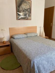 1 dormitorio con 1 cama y una foto en la pared en Apartamento en Montanejos, en Montanejos