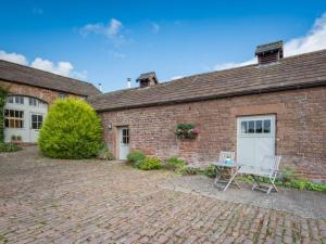 a brick building with a table and two chairs at 1 Bed in Eden Valley SZ237 in Kirkoswald