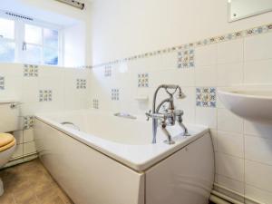 a white bathroom with a tub and a sink at 2 Bed in Patterdale SZ210 in Patterdale