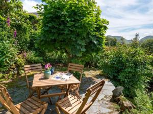 a wooden table with two chairs and a tree at 2 Bed in Patterdale SZ210 in Patterdale