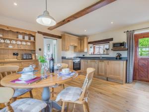 a kitchen and dining room with a wooden table and chairs at 2 Bed in Eden Valley SZ269 in Kirkoswald